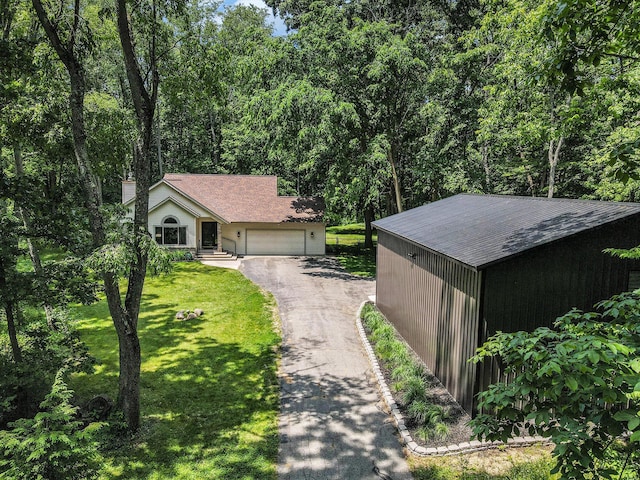 1355 N 7th St, Kalamazoo, MI 49009 - view of front of home with a front yard, asphalt driveway, a garage, and a view of trees