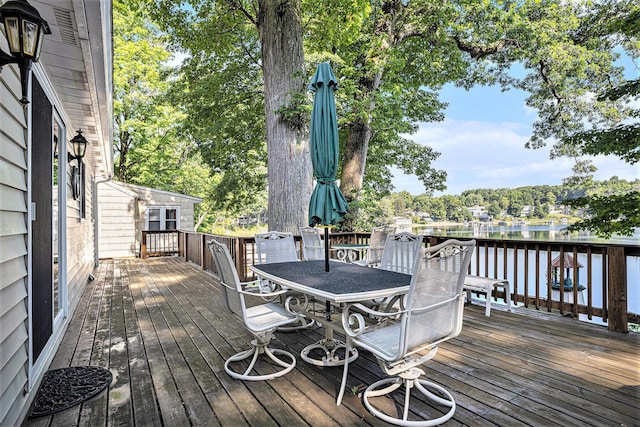 15891 Lakeview Dr, Buchanan, MI 49107 - wooden deck featuring outdoor dining area, a water view, and view of scattered trees