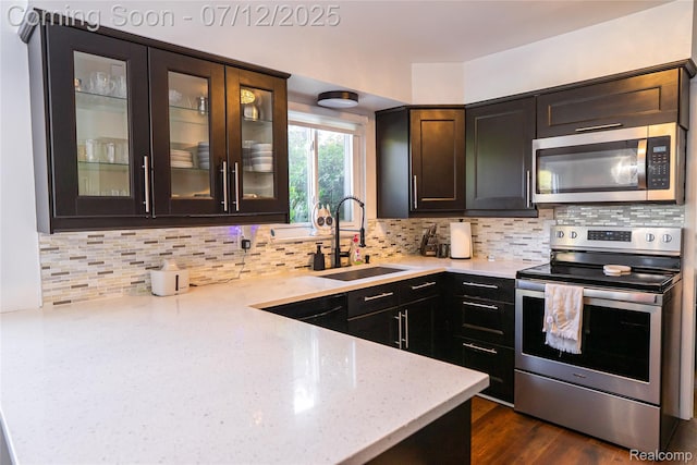 42331 Beacontree Ct, Northville, MI 48168 - kitchen with stainless steel appliances, light stone counters, tasteful backsplash, and glass insert cabinets