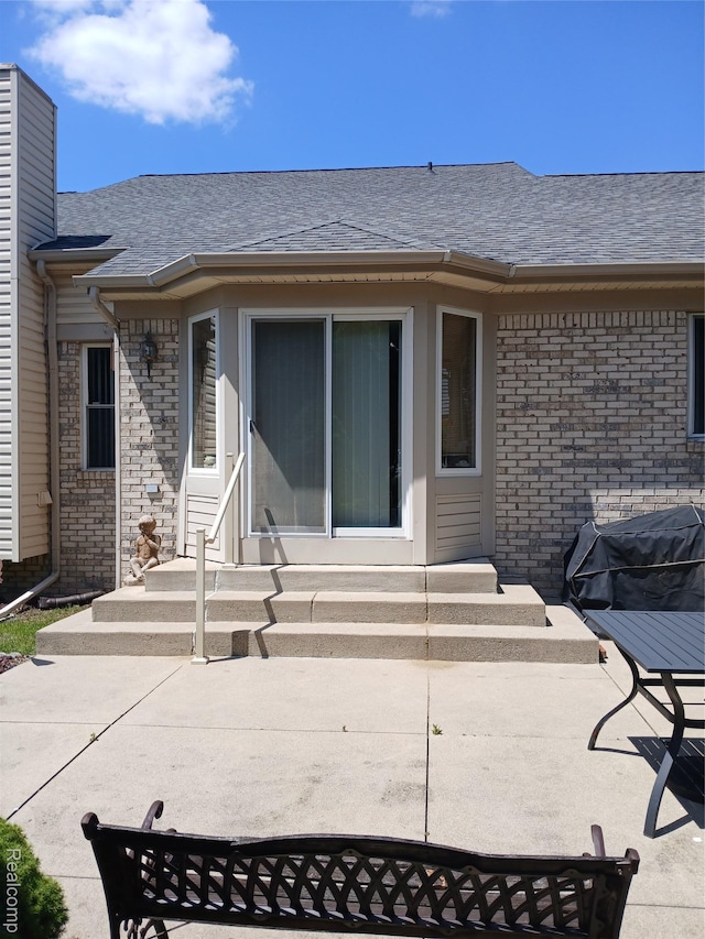 8086 Pickering Pl, Westland, MI 48185 - back of property featuring entry steps, brick siding, a chimney, roof with shingles, and a patio area