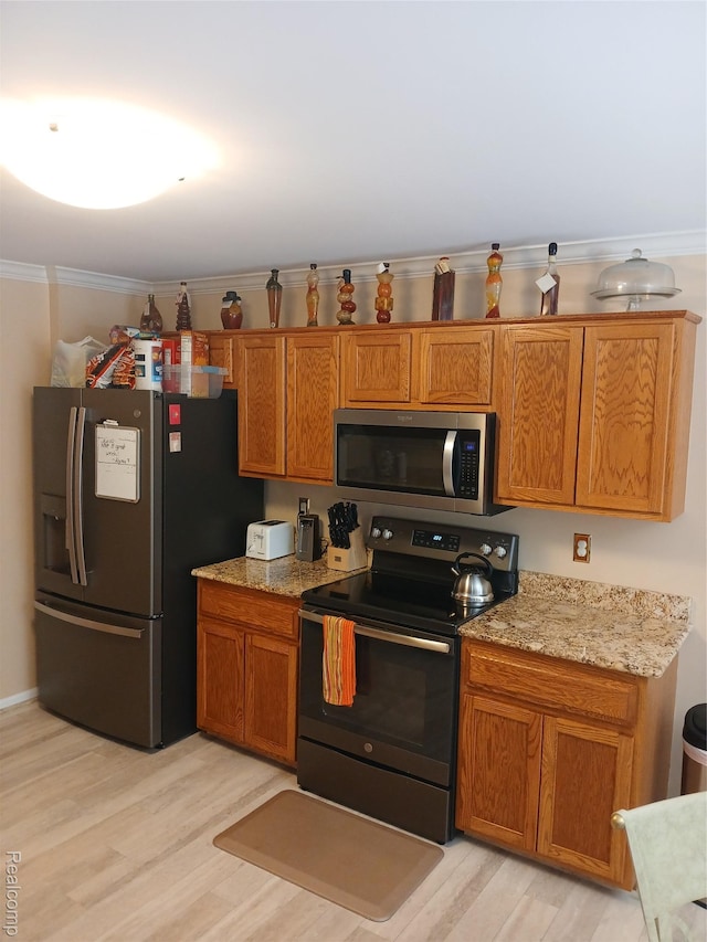 8086 Pickering Pl, Westland, MI 48185 - kitchen featuring appliances with stainless steel finishes, brown cabinetry, and light wood-type flooring