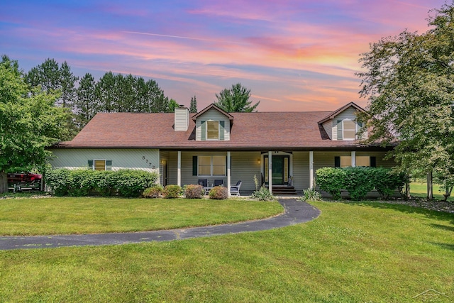 5772 Greensboro Way, Gladwin, MI 48624 - view of front of house featuring a chimney, a yard, and covered porch