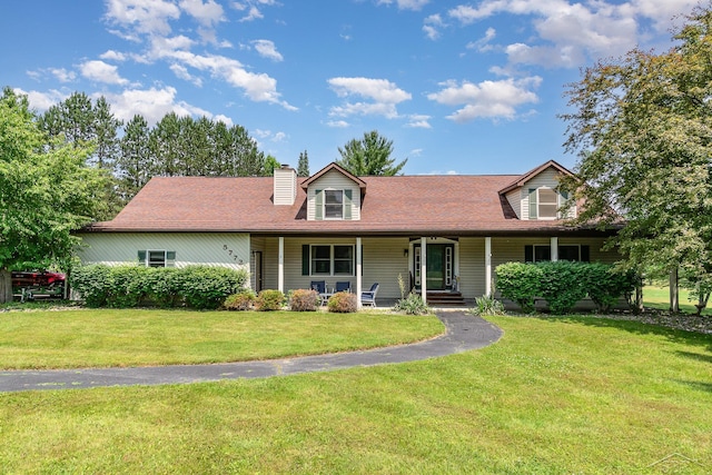 5772 Greensboro Way, Gladwin, MI 48624 - view of front facade with a front yard, a chimney, and covered porch