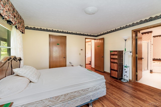 5772 Greensboro Way, Gladwin, MI 48624 - bedroom with wood finished floors and ensuite bath