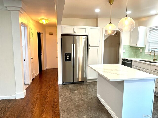 20979 Audette St, Dearborn, MI 48124 - kitchen featuring stainless steel appliances, white cabinets, light countertops, backsplash, and decorative light fixtures