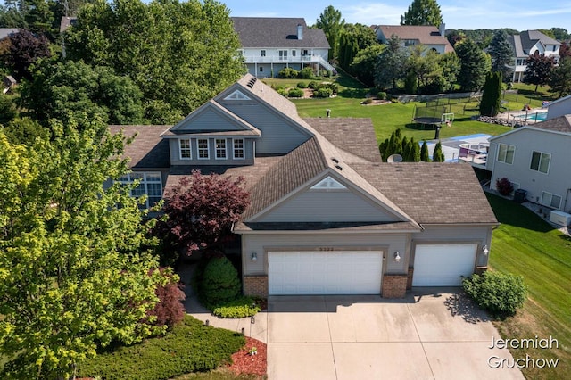 5322 S Silverstone Dr NE, Comstock Park, MI 49321 - view of front of house with brick siding, an attached garage, driveway, and a front lawn