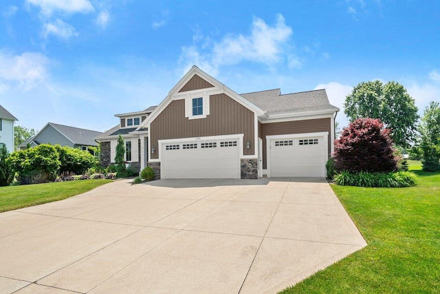 1560 Marksbury Ct, Byron Center, MI 49315 - craftsman-style house featuring an attached garage, a front lawn, stone siding, and concrete driveway