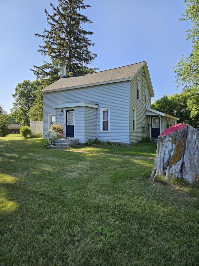 8991 W 1 Mile Rd, Hesperia, MI 49421 - back of house featuring a chimney and a lawn