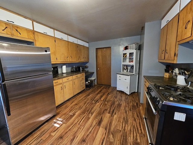 8991 W 1 Mile Rd, Hesperia, MI 49421 - kitchen featuring freestanding refrigerator, range with gas cooktop, dark wood-style flooring, dark countertops, and brown cabinetry