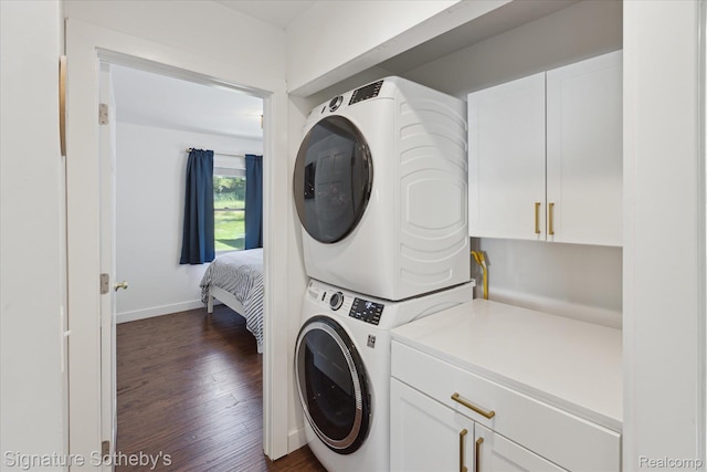4294 N E Torch Lake Dr, Central Lake, MI 49622 - laundry area with stacked washer / drying machine, dark wood finished floors, and cabinet space