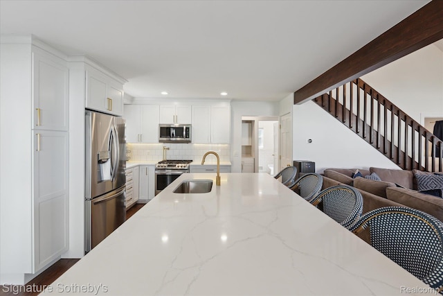 4294 N E Torch Lake Dr, Central Lake, MI 49622 - kitchen featuring appliances with stainless steel finishes, white cabinetry, backsplash, open floor plan, and recessed lighting