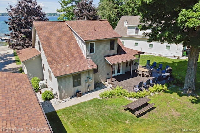 4294 N E Torch Lake Dr, Central Lake, MI 49622 - back of property featuring a deck with water view, roof with shingles, a lawn, outdoor dining space, and french doors