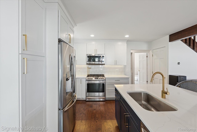 4294 N E Torch Lake Dr, Central Lake, MI 49622 - kitchen with stainless steel appliances, white cabinets, decorative backsplash, dark wood-style flooring, and recessed lighting
