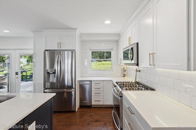 4294 N E Torch Lake Dr, Central Lake, MI 49622 - kitchen with stainless steel appliances, white cabinetry, recessed lighting, light stone counters, and dark wood finished floors
