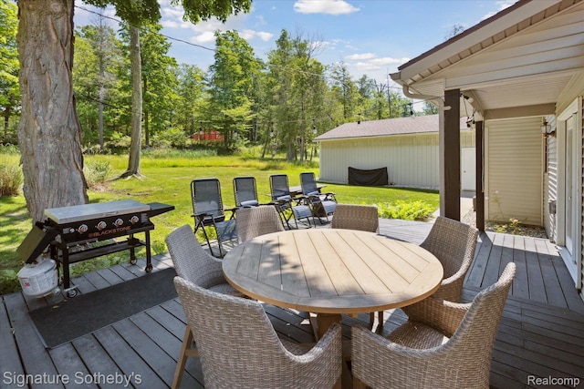 4294 N E Torch Lake Dr, Central Lake, MI 49622 - wooden deck featuring outdoor dining area, a lawn, and view of scattered trees