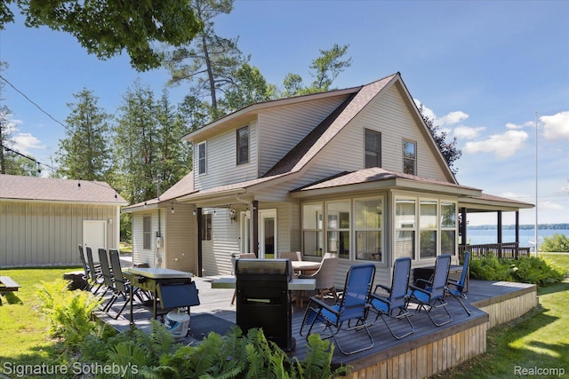 4294 N E Torch Lake Dr, Central Lake, MI 49622 - back of property with a deck with water view, outdoor dining area, a shingled roof, and a sunroom