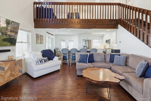 4294 N E Torch Lake Dr, Central Lake, MI 49622 - living area with dark wood-style flooring, a towering ceiling, and stairs
