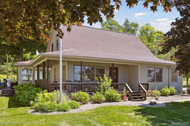 4294 N E Torch Lake Dr, Central Lake, MI 49622 - farmhouse featuring a front lawn, a shingled roof, and covered porch