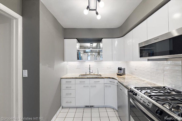1982 Wickham St, Royal Oak, MI 48073 - kitchen featuring appliances with stainless steel finishes, decorative backsplash, light tile patterned floors, white cabinetry, and light stone counters