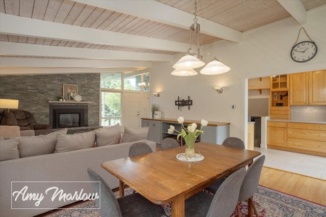 708 Magnolia Ct, Big Rapids, MI 49307 - dining space featuring light wood-style flooring, a glass covered fireplace, and wooden ceiling
