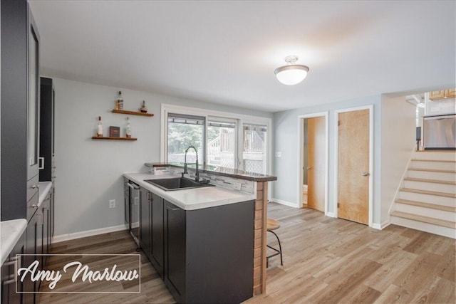708 Magnolia Ct, Big Rapids, MI 49307 - kitchen with a kitchen breakfast bar, a peninsula, light countertops, and light wood-style flooring