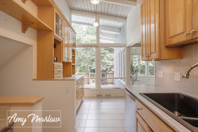 708 Magnolia Ct, Big Rapids, MI 49307 - kitchen with dishwashing machine, light countertops, light tile patterned flooring, and backsplash