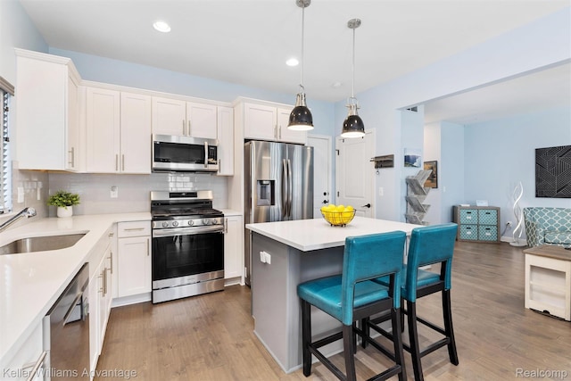 38 E Dallas Ave, Madison Heights, MI 48071 - kitchen with appliances with stainless steel finishes, a kitchen breakfast bar, wood finished floors, white cabinetry, and recessed lighting