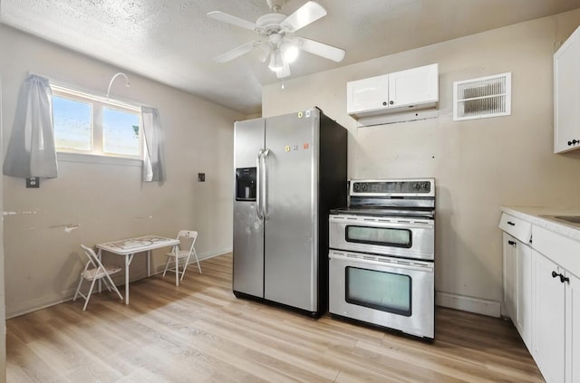 1079 Hurd Ave, Benton Harbor, MI 49022 - kitchen with appliances with stainless steel finishes, light wood-type flooring, white cabinets, a ceiling fan, and light countertops