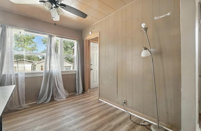 1079 Hurd Ave, Benton Harbor, MI 49022 - unfurnished dining area featuring a ceiling fan, wood walls, and wood finished floors