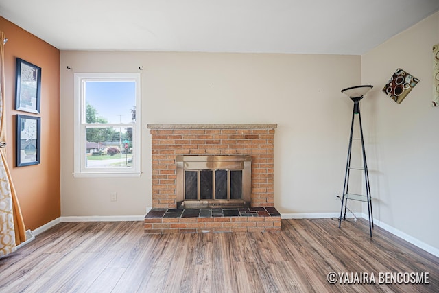 2751 Valley Ave NW, Grand Rapids, MI 49544 - unfurnished living room with wood finished floors and a brick fireplace