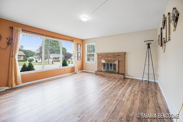 2751 Valley Ave NW, Grand Rapids, MI 49544 - unfurnished living room with wood finished floors and a brick fireplace
