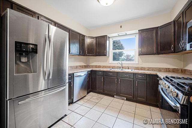 2751 Valley Ave NW, Grand Rapids, MI 49544 - kitchen featuring stainless steel appliances, dark brown cabinets, light tile patterned floors, and light countertops