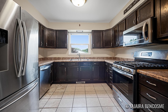 2751 Valley Ave NW, Grand Rapids, MI 49544 - kitchen featuring appliances with stainless steel finishes, light tile patterned flooring, and dark brown cabinets
