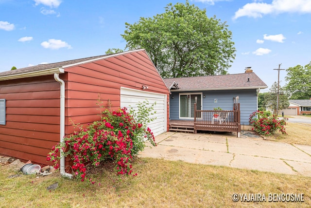 2751 Valley Ave NW, Grand Rapids, MI 49544 - back of property with a chimney, a wooden deck, and a garage