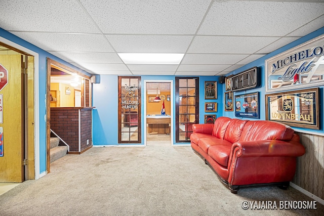 2751 Valley Ave NW, Grand Rapids, MI 49544 - carpeted living area featuring a drop ceiling, stairway, and wooden walls