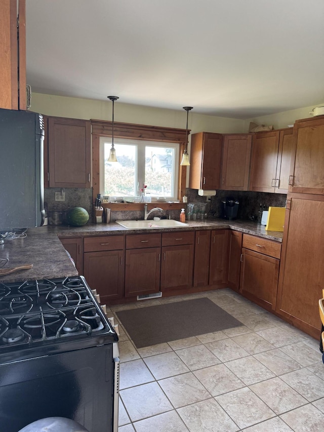 3338 Abbey Rd, Hart, MI 49420 - kitchen featuring gas range, refrigerator, decorative backsplash, and hanging light fixtures