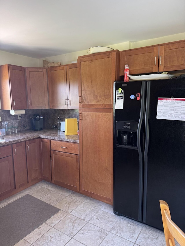 3338 Abbey Rd, Hart, MI 49420 - kitchen featuring black refrigerator with ice dispenser, decorative backsplash, light stone finish floors, and brown cabinets