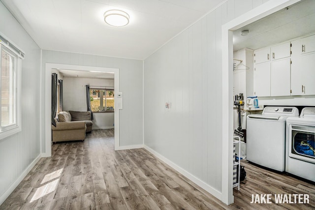 816 Malta St NE, Grand Rapids, MI 49503 - washroom featuring separate washer and dryer, light wood-style floors, and cabinet space