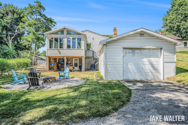 816 Malta St NE, Grand Rapids, MI 49503 - rear view of property featuring a fire pit, a lawn, concrete driveway, and a chimney
