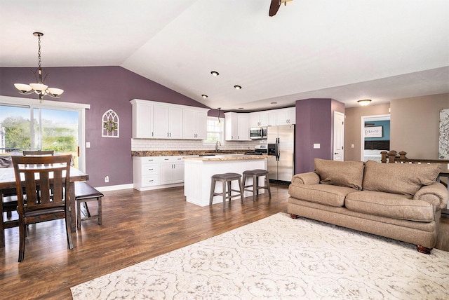13757 Duncan St, Holland, MI 49424 - living area featuring lofted ceiling, dark wood-style floors, and a chandelier