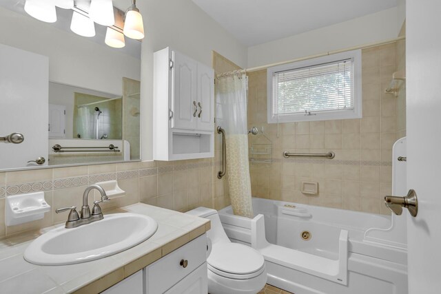 1007 Oak Grove Rd, Jackson, MI 49203 - full bath featuring vanity, a combined bath / shower with jetted tub, decorative backsplash, and tile walls