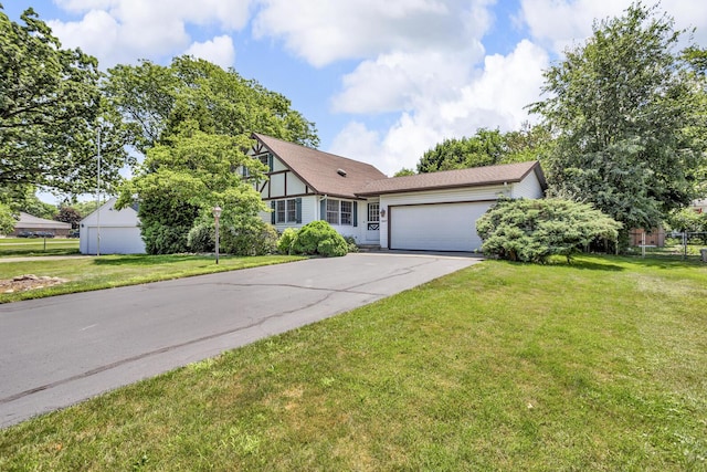 1007 Oak Grove Rd, Jackson, MI 49203 - view of front of home with an attached garage, asphalt driveway, and a front lawn