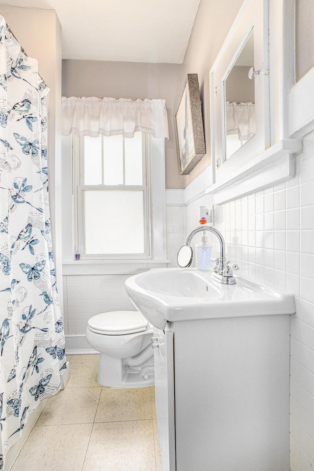 618 Madison St, Jackson, MI 49202 - full bath featuring tile walls, vanity, wainscoting, and curtained shower