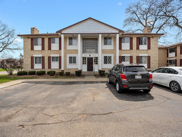 29272 Gloede Dr Unit 16, Warren, MI 48088 - view of front facade with a chimney and uncovered parking
