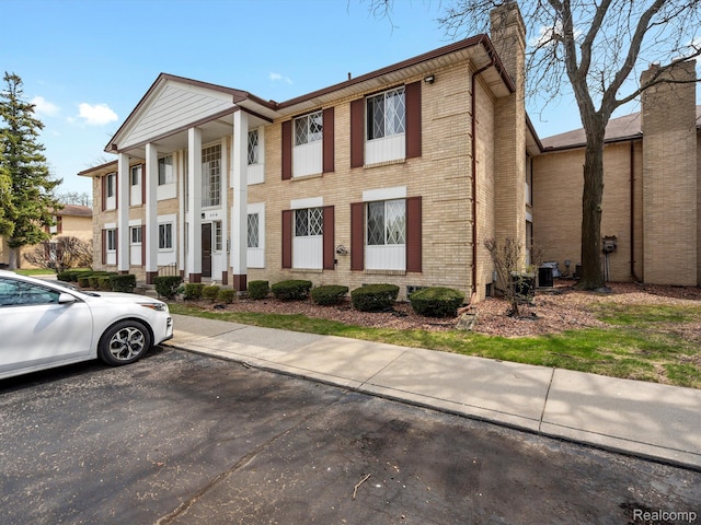 29272 Gloede Dr Unit 16, Warren, MI 48088 - greek revival house with a chimney, brick siding, and uncovered parking