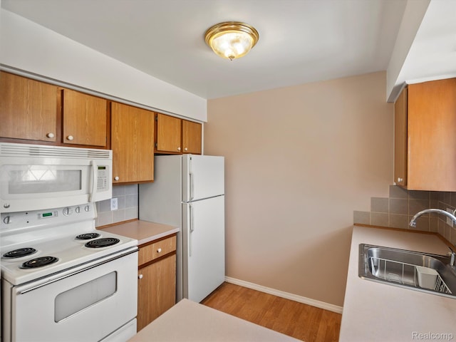 29272 Gloede Dr Unit 16, Warren, MI 48088 - kitchen featuring white appliances, light wood finished floors, brown cabinets, and backsplash