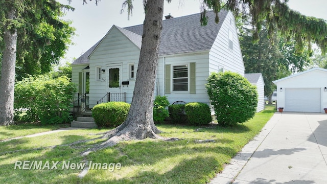 508 Malzahn St, Saginaw, MI 48602 - view of front of property with a shingled roof, an outdoor structure, concrete driveway, and a front yard