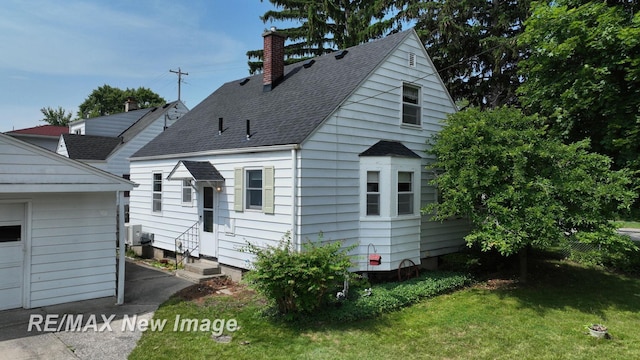 508 Malzahn St, Saginaw, MI 48602 - view of front of home featuring a chimney, roof with shingles, entry steps, a front yard, and a garage