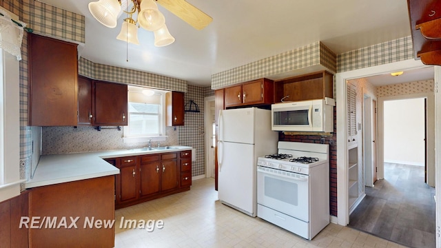 508 Malzahn St, Saginaw, MI 48602 - kitchen with wallpapered walls, white appliances, ceiling fan, light countertops, and light floors