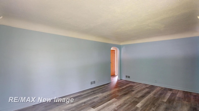 508 Malzahn St, Saginaw, MI 48602 - spare room with arched walkways and dark wood-type flooring